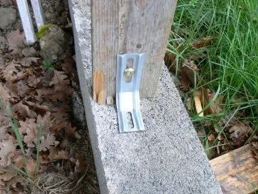 fixation du montant au parpaing avec une équerre métalique